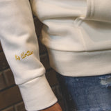 Its Written printed on wrist of maktoob cream hoodie