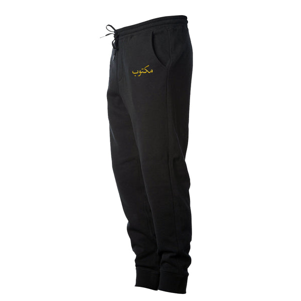 Black Arabic Maktoob Fleece Pants with Gold Embroidered Logo. It Is Written